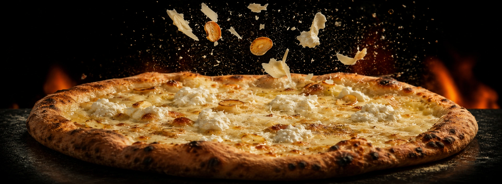 A finished wood-fired pizza with ricotta and roasted garlic